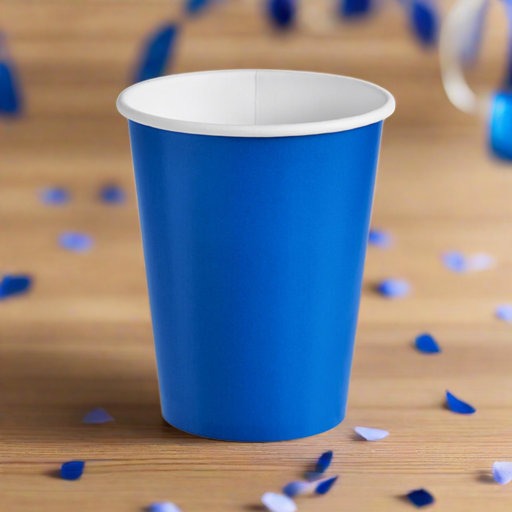 cobalt blue, 9 oz paper party cup for hot and cold drinks, sitting on wood table with blue confetti